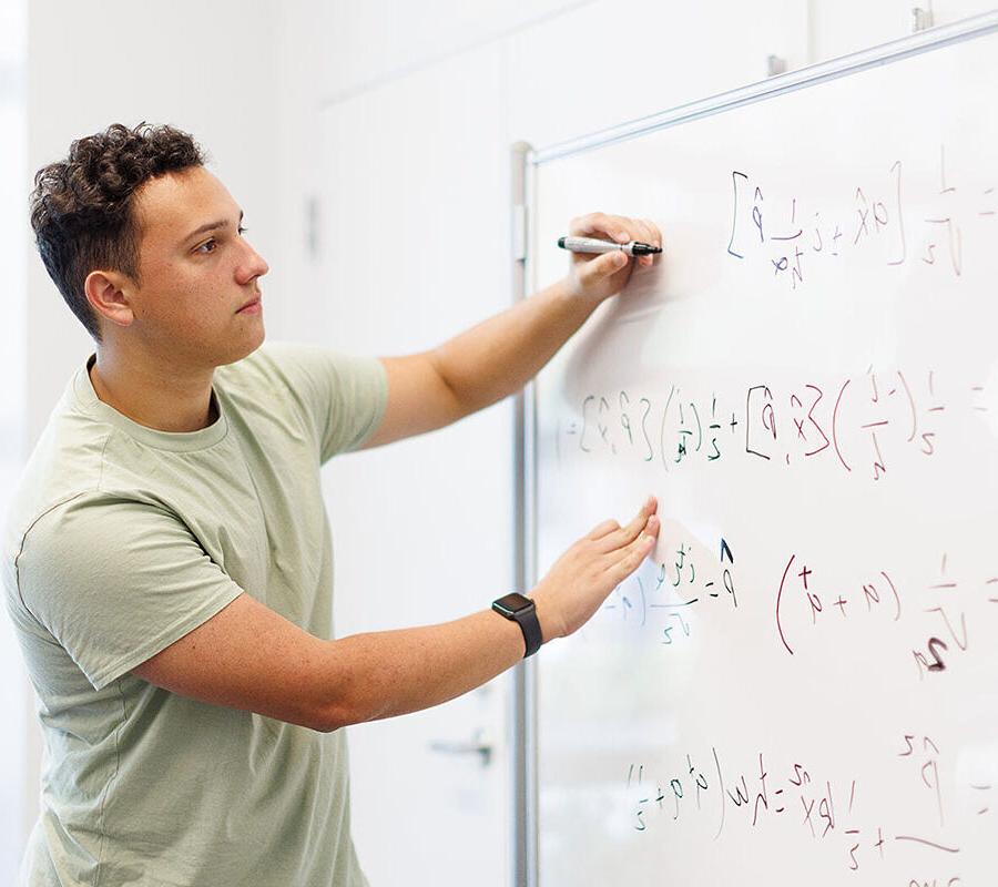 一般工程专业的学生在白板上写方程式.